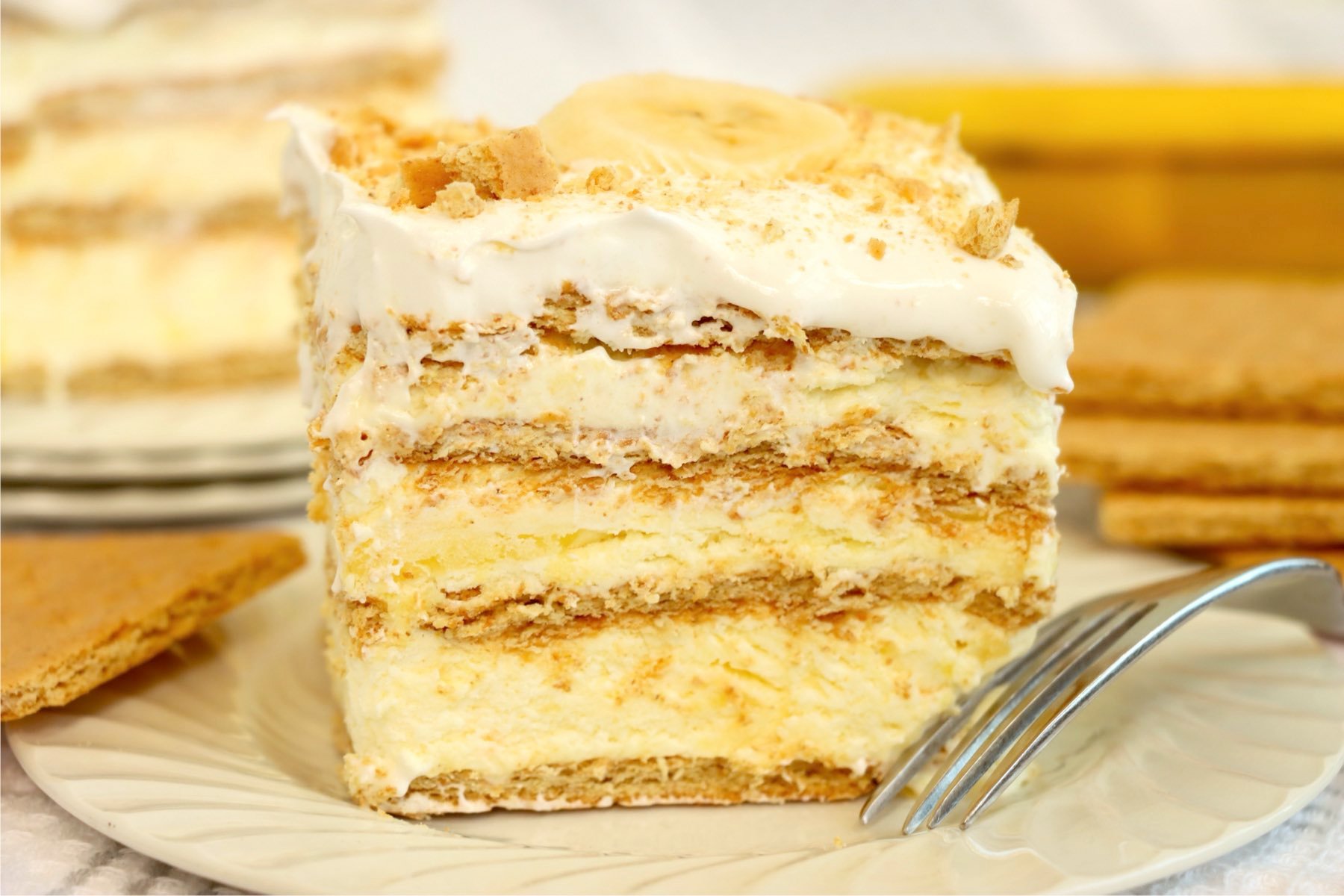 A layered Banana Pudding Icebox Cake topped with whipped cream and banana slice.