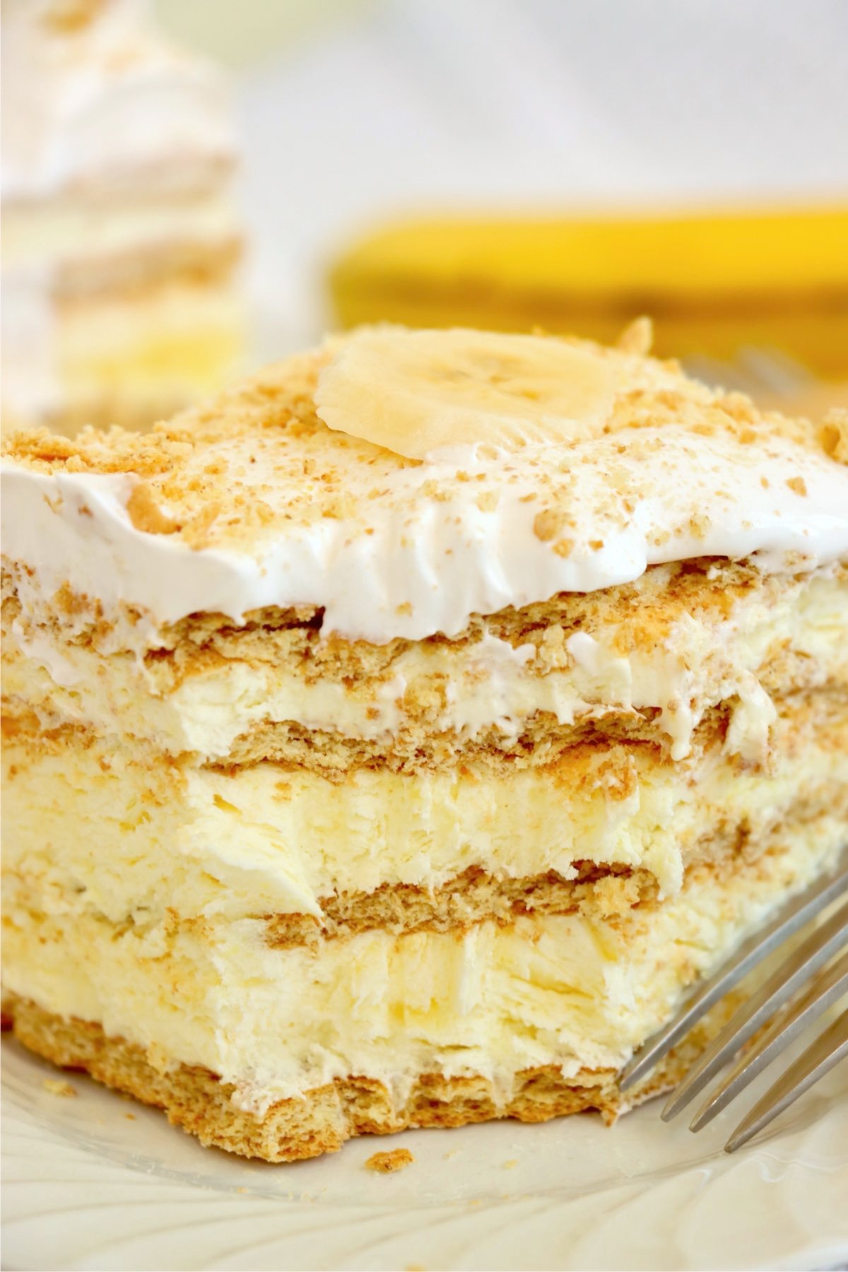 A close-up of banana pudding icebox cake showing creamy layers and a banana slice on top.