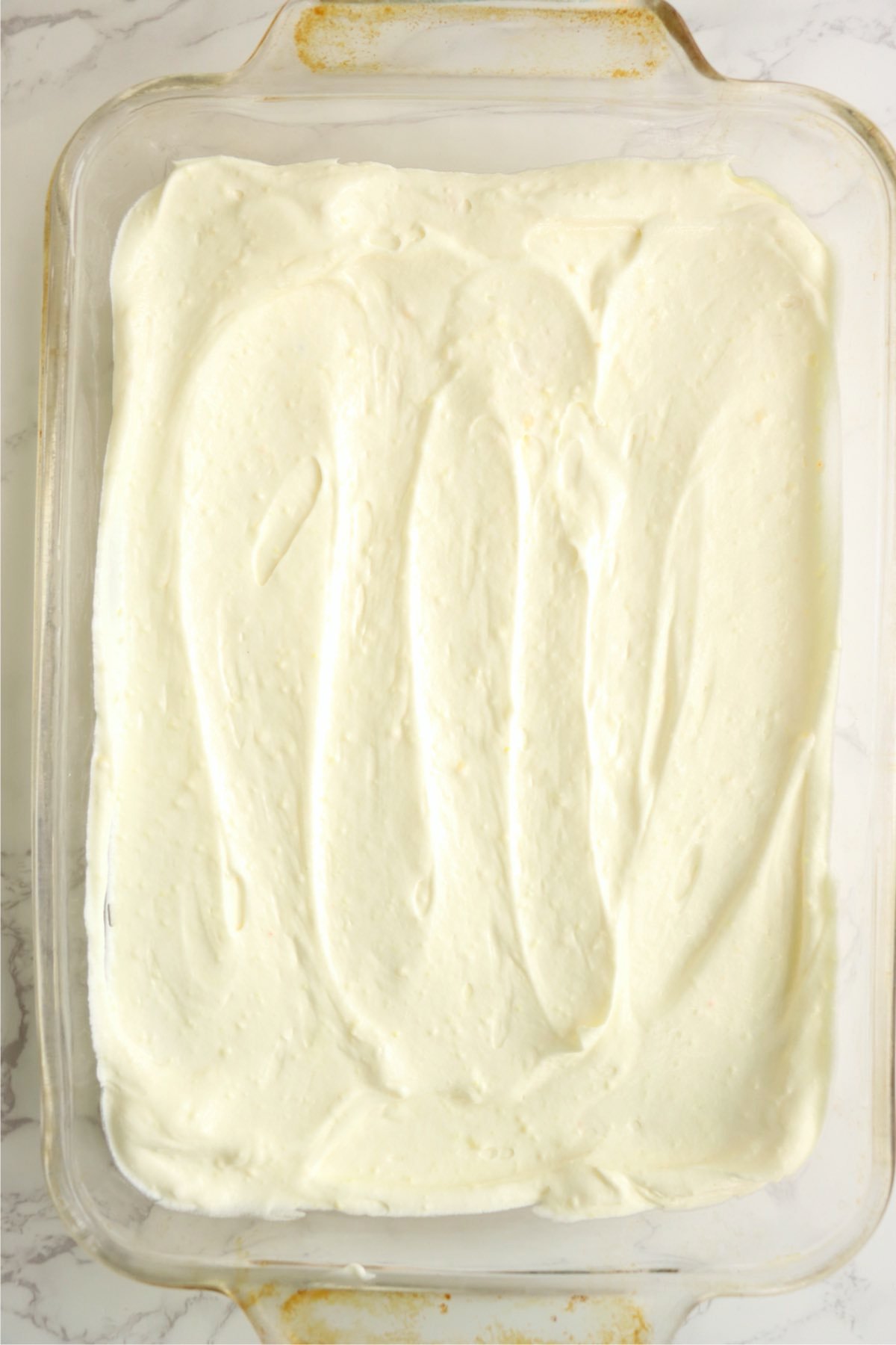Creamy banana pudding layer spread over the graham crackers in the baking dish.