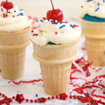Group of frosted cupcake cones arranged on a table with red and white decorations.