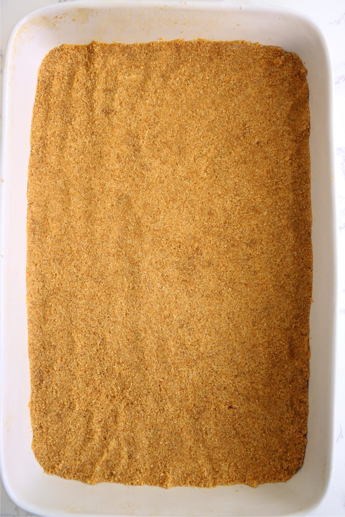 Graham cracker crust pressed into the bottom of a 9x13-inch baking dish.