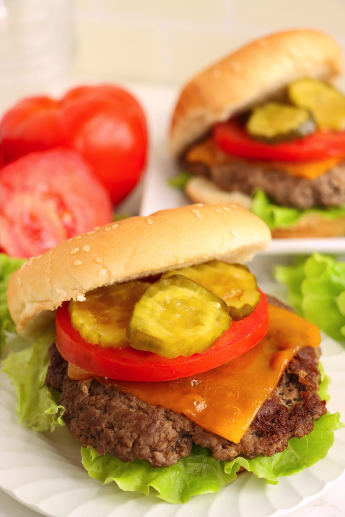Cheeseburger with classic toppings on a paper plate.