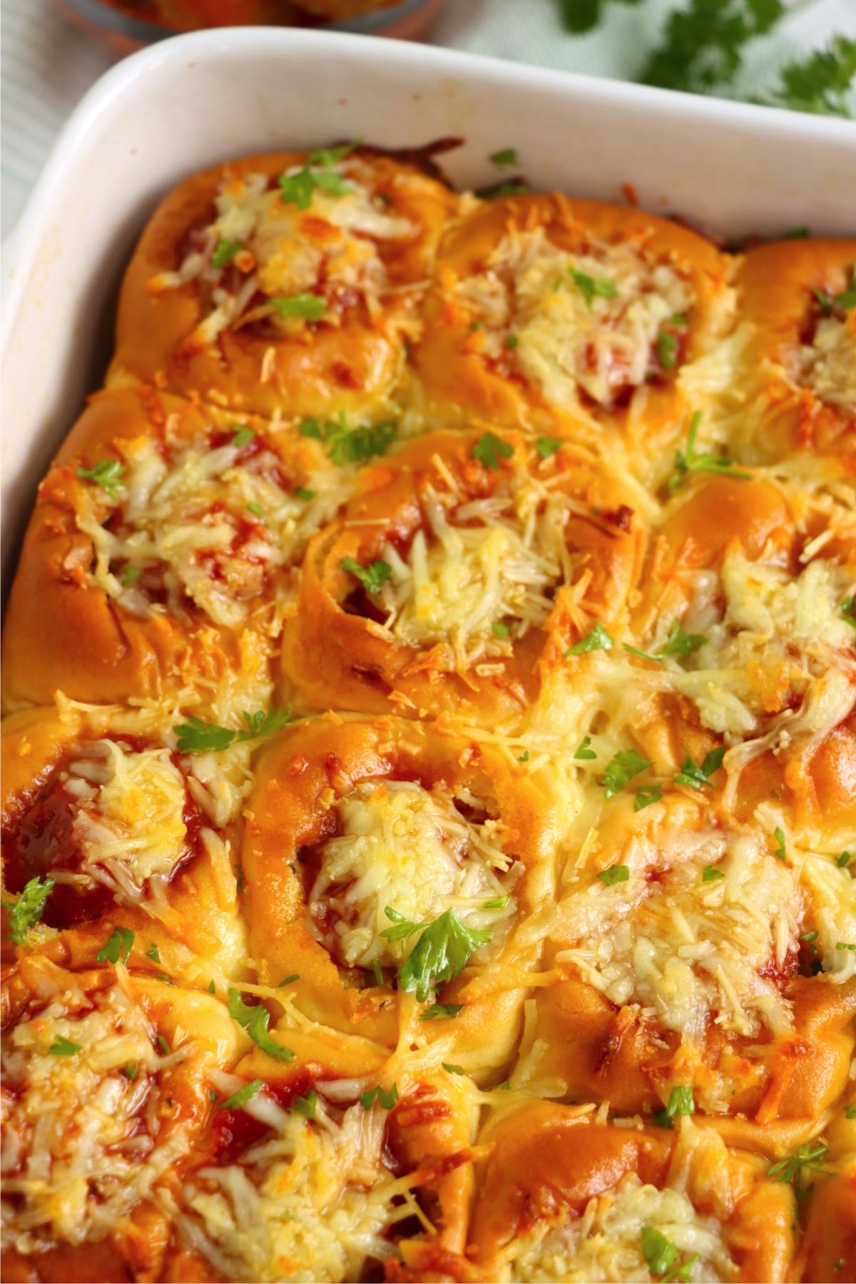 Golden, cheesy sliders garnished with fresh parsley.