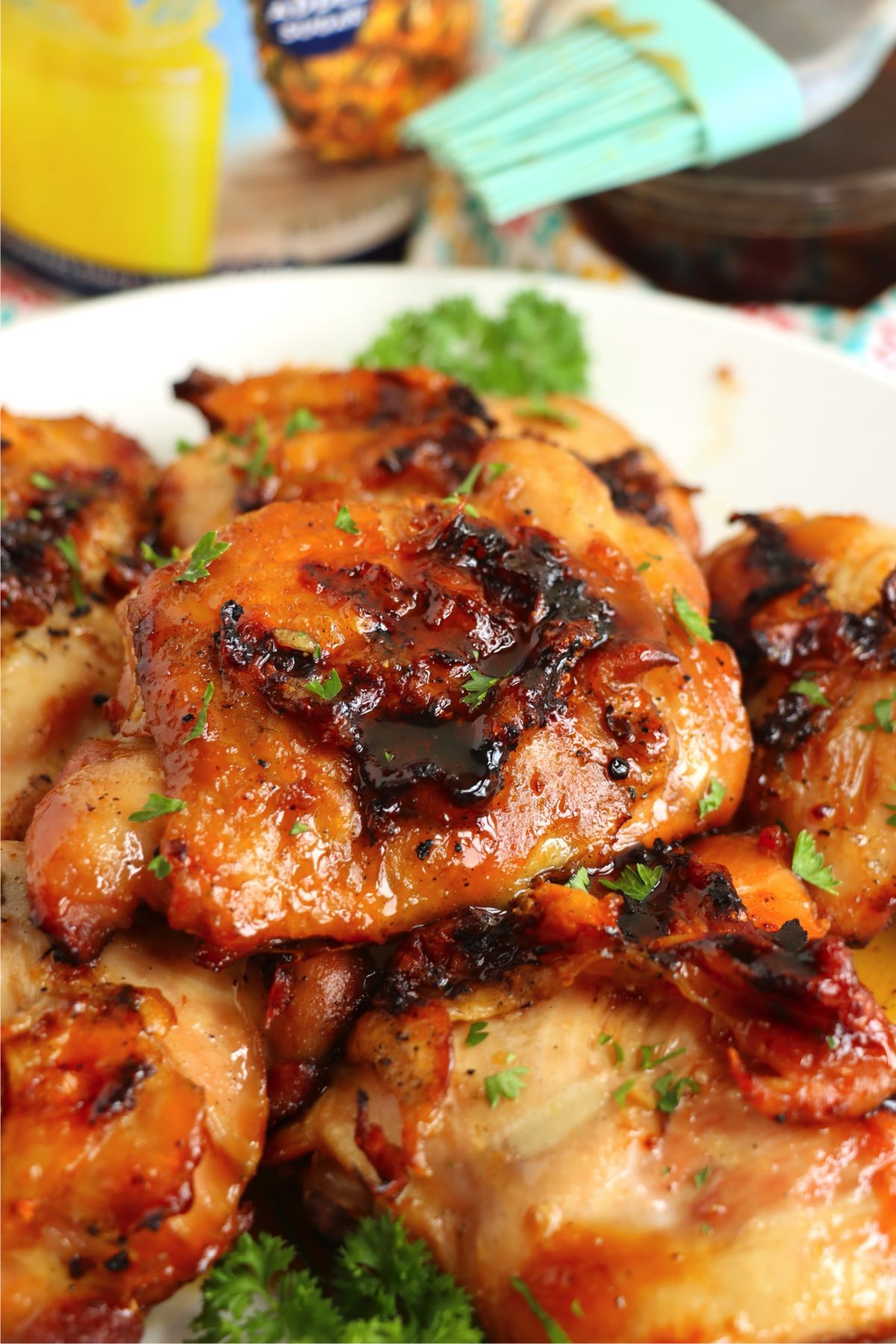 A platter of grilled tropical chicken thighs, garnished with parsley and ready to serve.