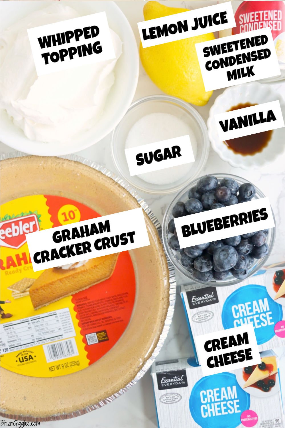All ingredients for blueberry icebox pie, including crust, cream cheese, whipped topping, and blueberries.