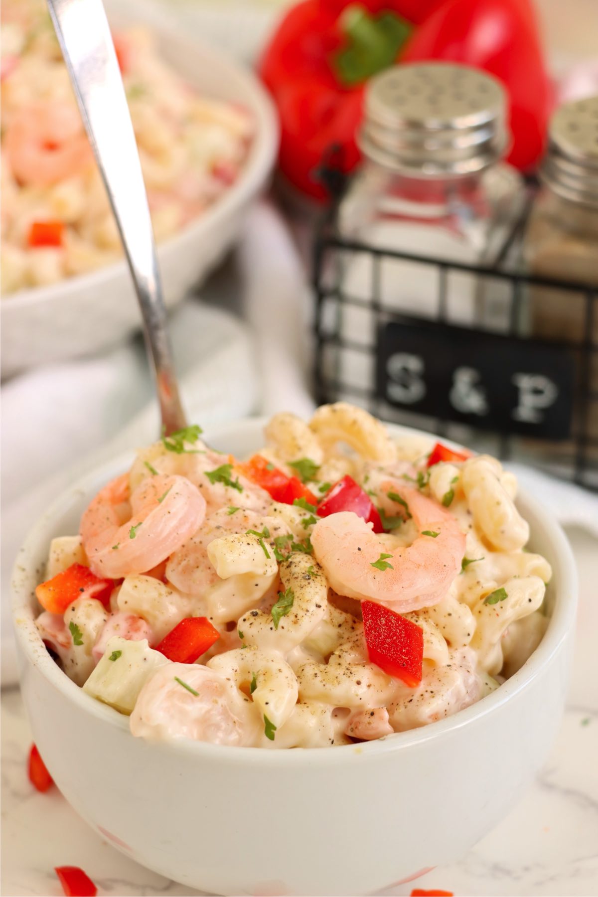Small bowl of shrimp pasta salad ready to serve with a fork.