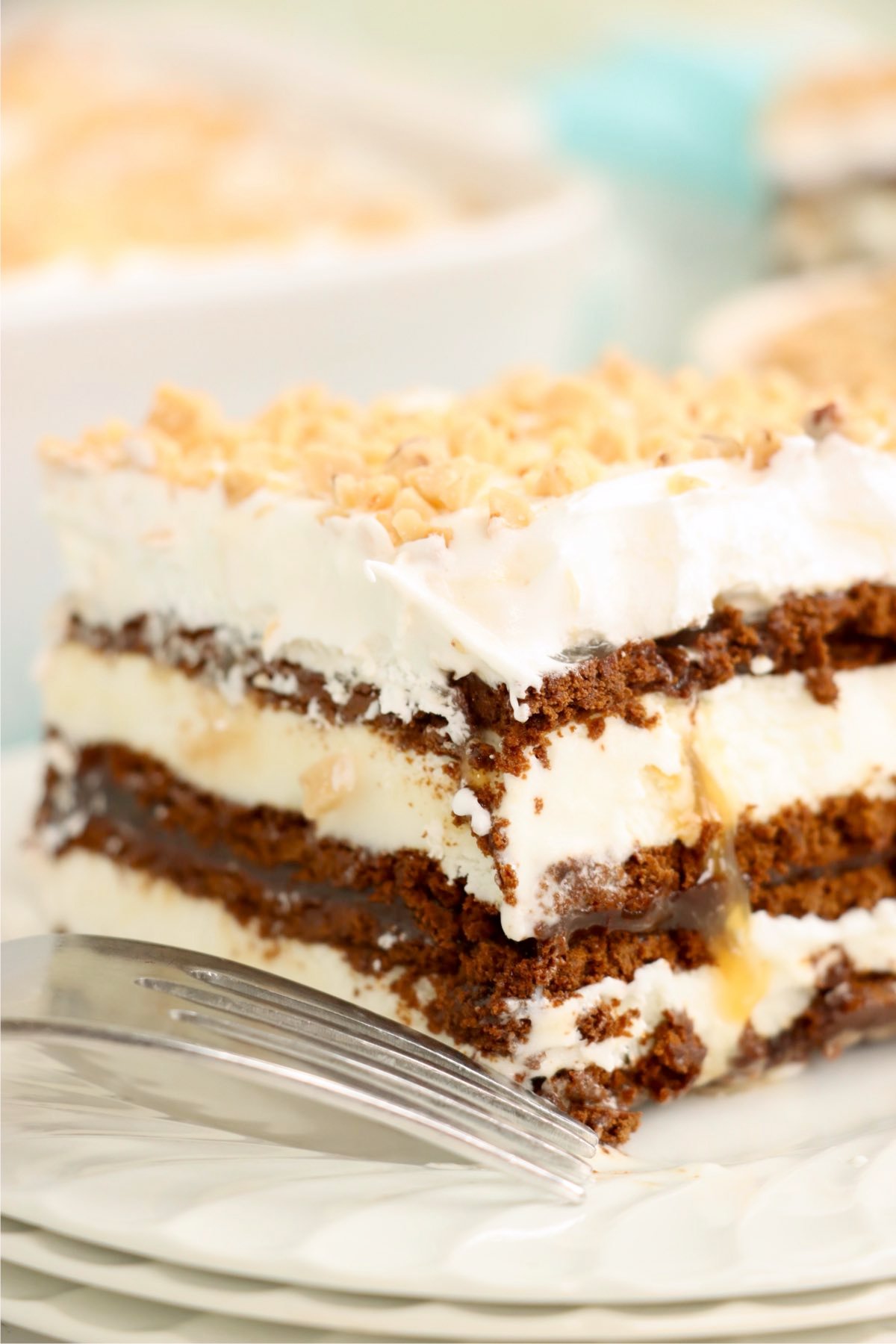 Ice cream sandwich dessert showing layers of ice cream sandwiches, chocolate, caramel, and whipped topping.