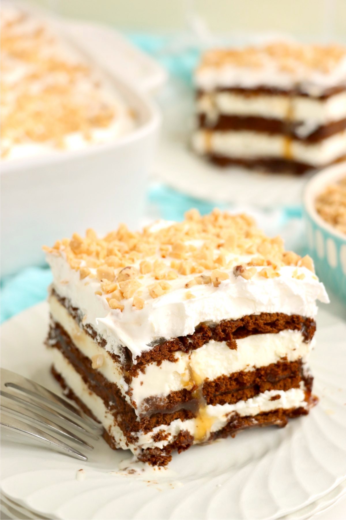 A full slice of a layered dessert served on a white plate with a fork.