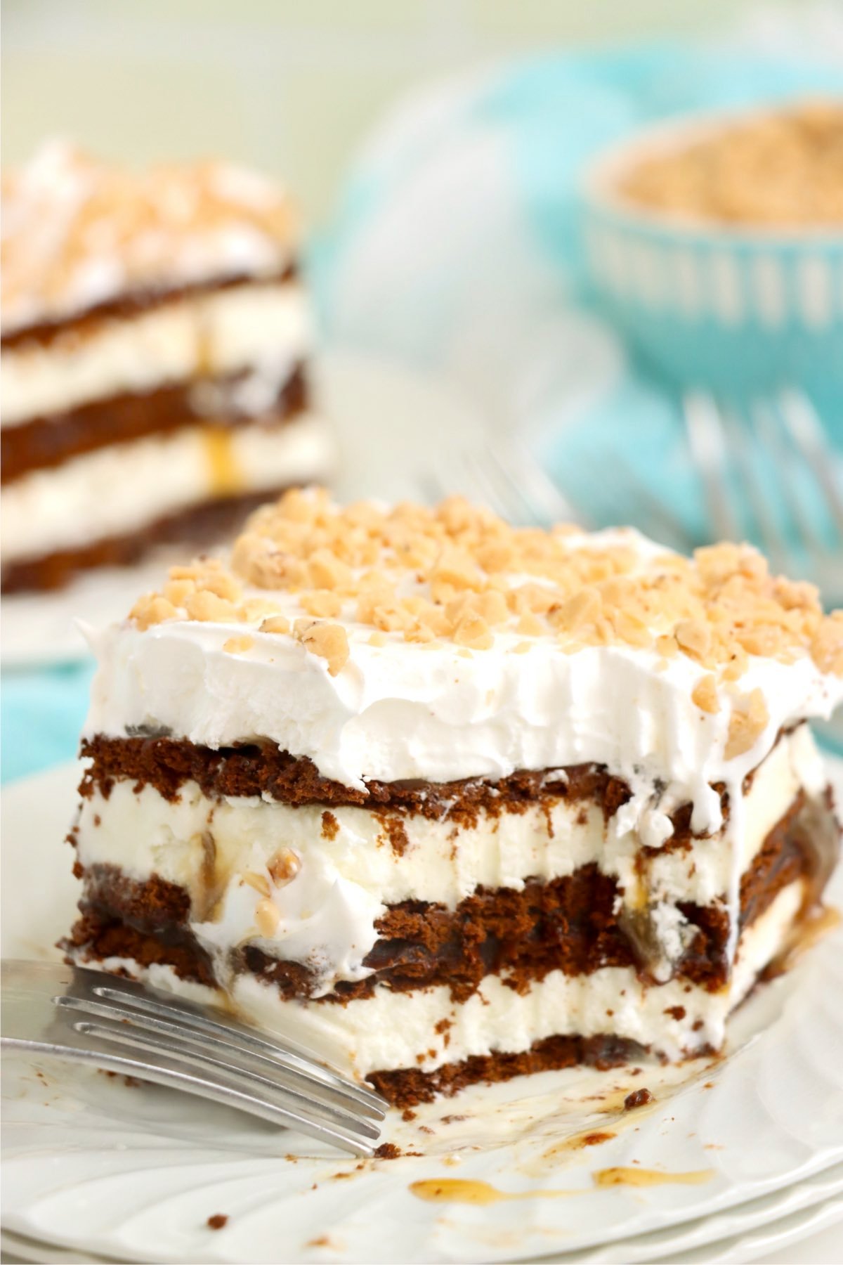A plated slice of ice cream sandwich dessert topped with whipped topping and crushed toffee bits.