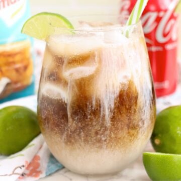 Iced drink garnished with a lime wedge and green striped straw.