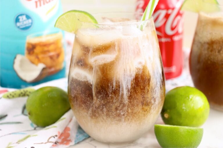 Iced drink garnished with a lime wedge and green striped straw.