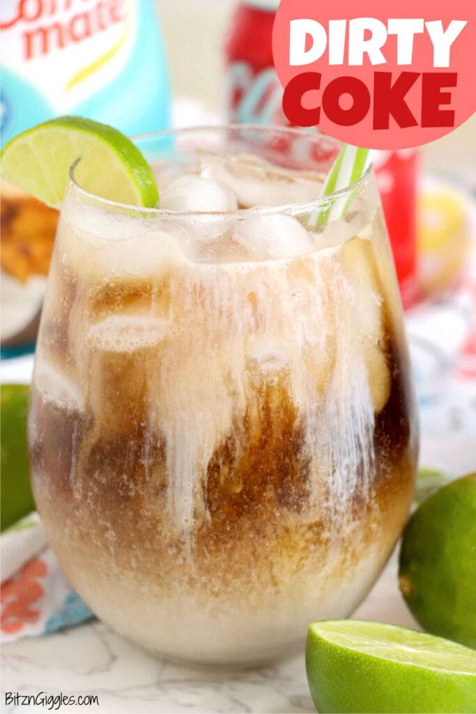 Close-up of a fizzy drink with ice, lime wedge, and creamy layers swirling together.