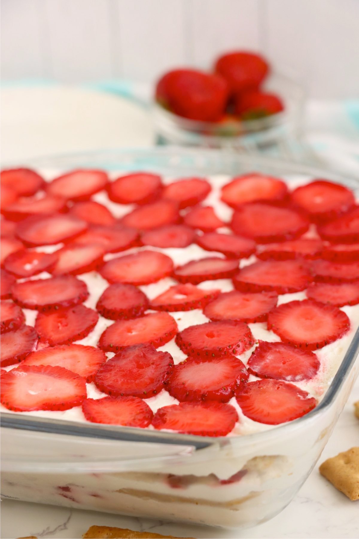 Side view of the layered strawberry icebox cake in a glass dish.