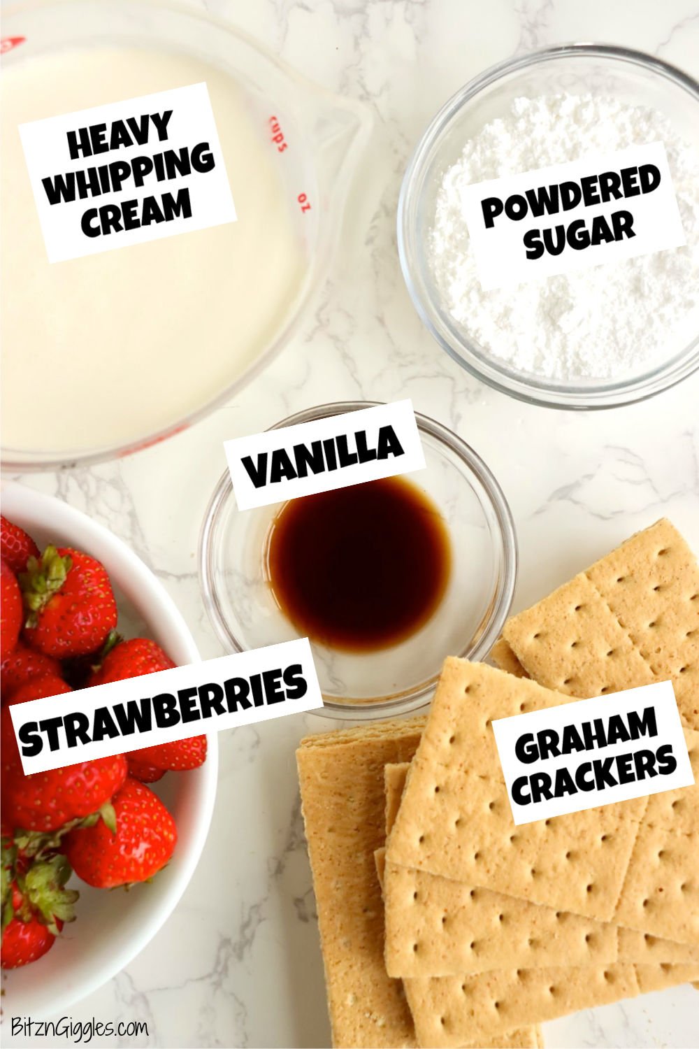 Ingredients for strawberry icebox cake, including cream, powdered sugar, vanilla, strawberries, and graham crackers laid out on a white surface.