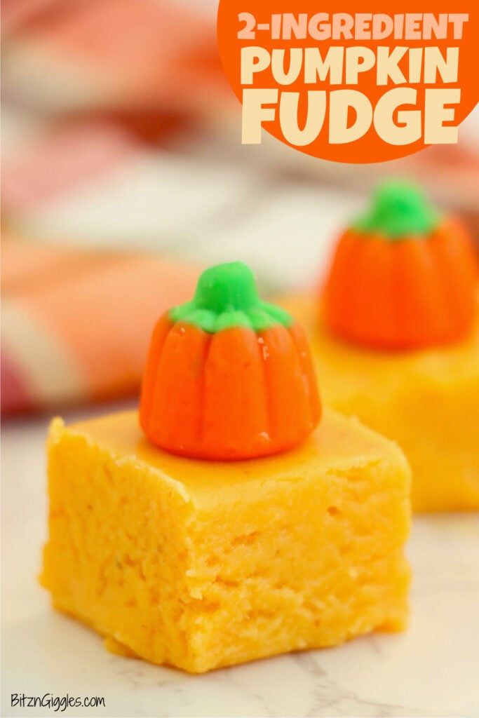 Pumpkin fudge square with a candy pumpkin on top, shown in front of blurred fall decor.