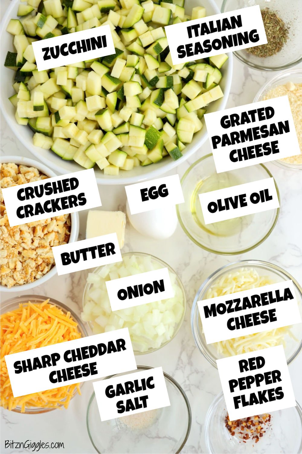 Ingredients for cheesy zucchini bake arranged on a counter including zucchini, cheese, onion, crackers, butter, and seasonings.