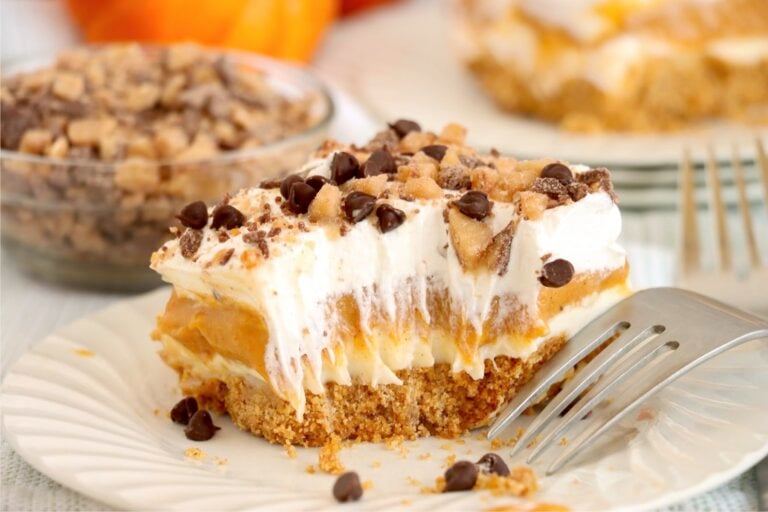 A plated slice of the pumpkin dessert showing the graham crust, cream cheese layer, and pumpkin layer.