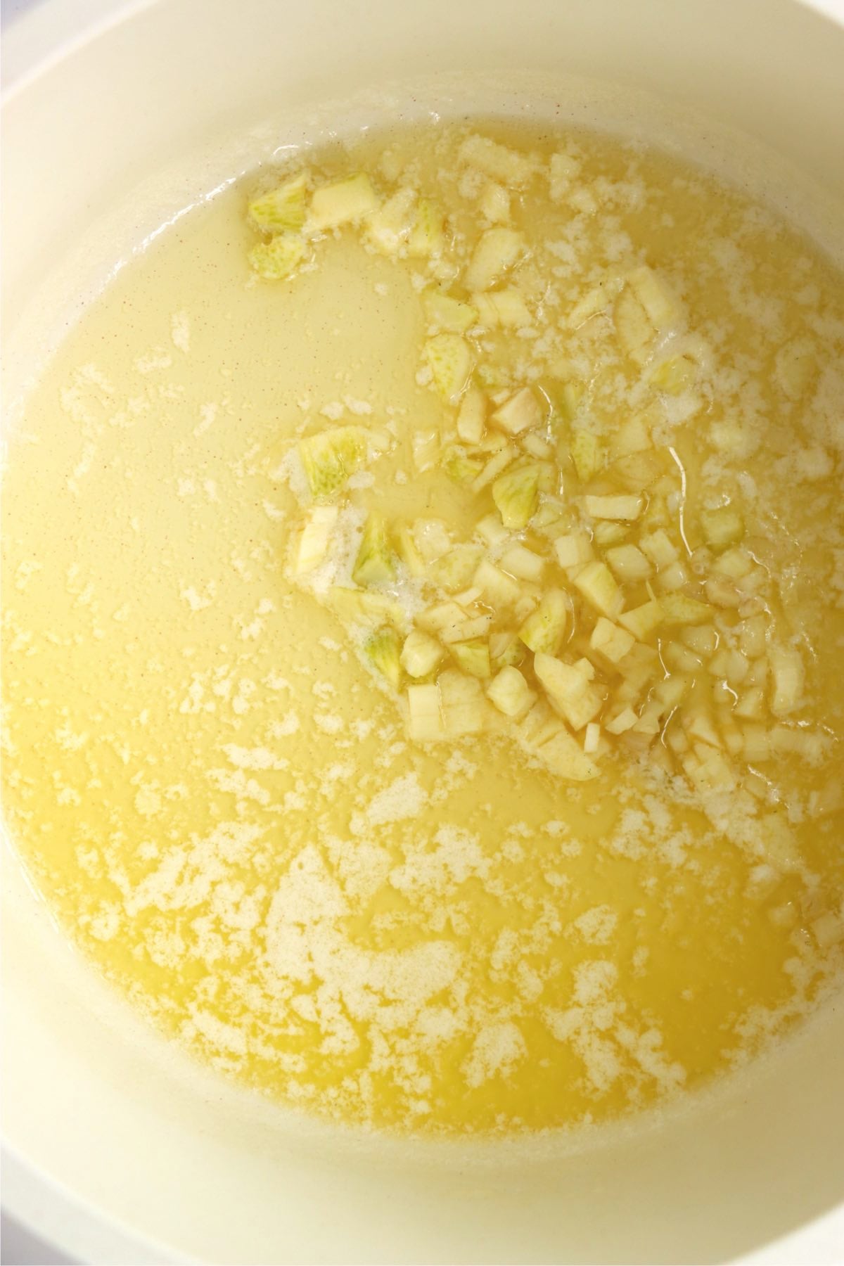Melted butter with minced garlic in a saucepan, beginning the garlic butter sauce.