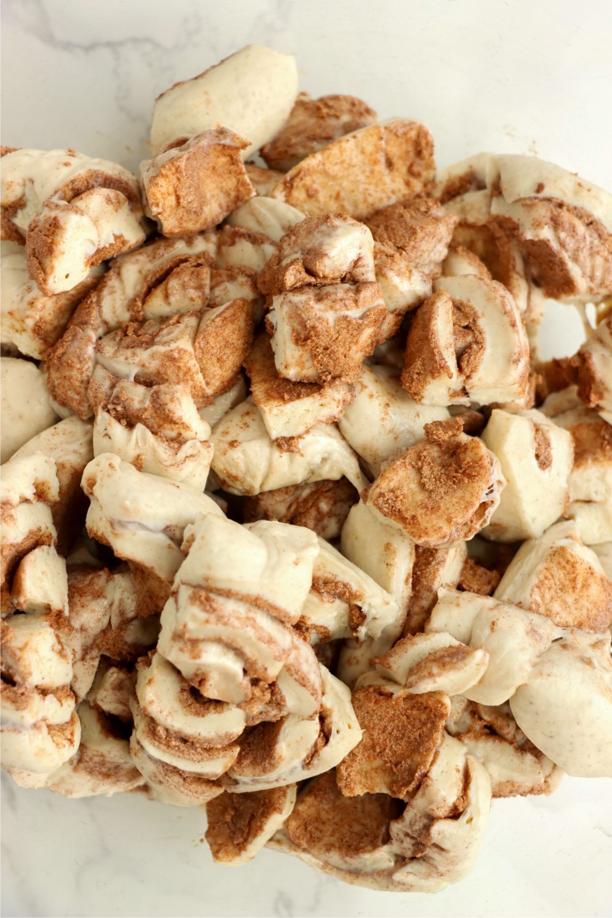 A bowl filled with chopped cinnamon roll pieces.