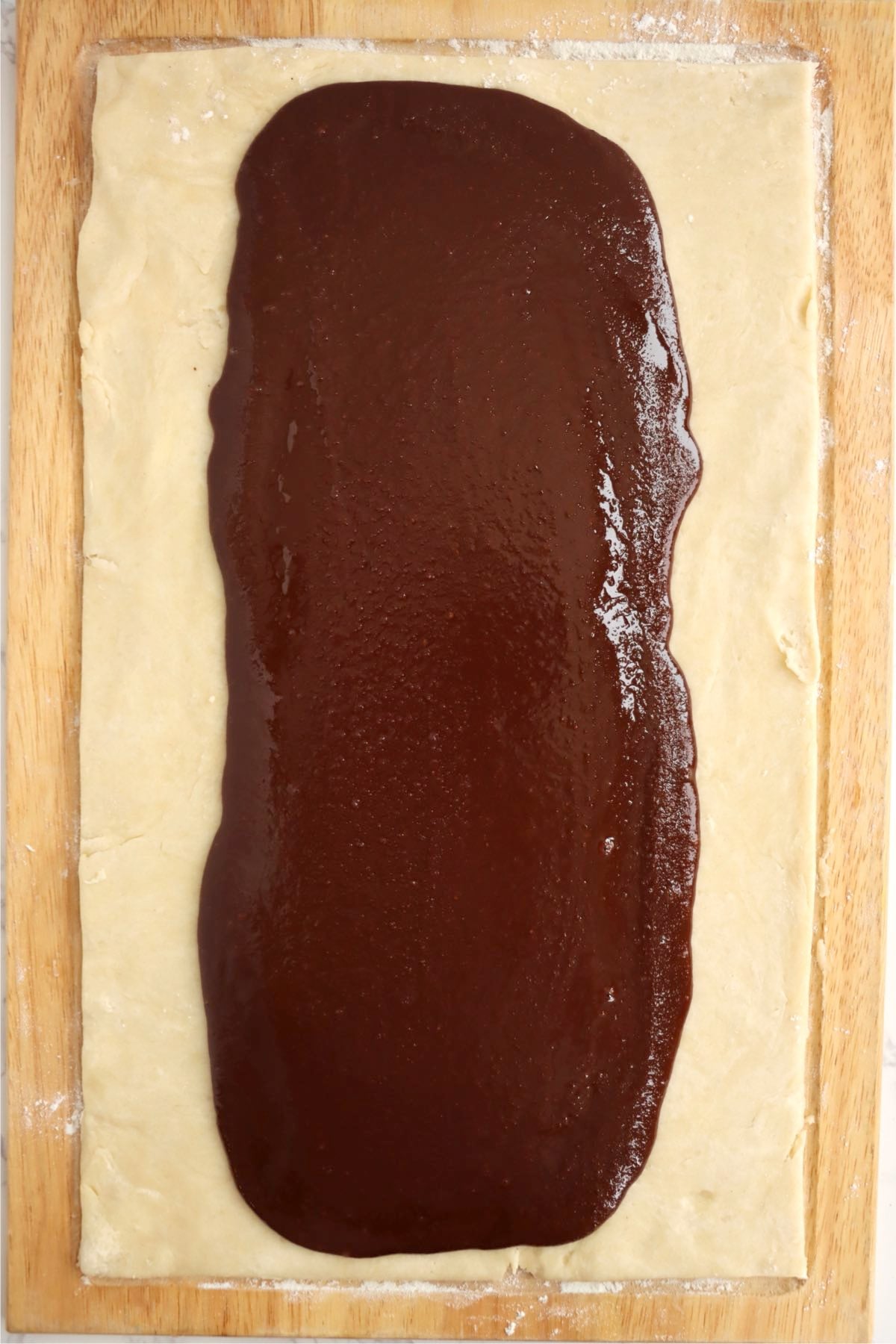 Chocolate filling spread down the center of the rolled pastry dough.