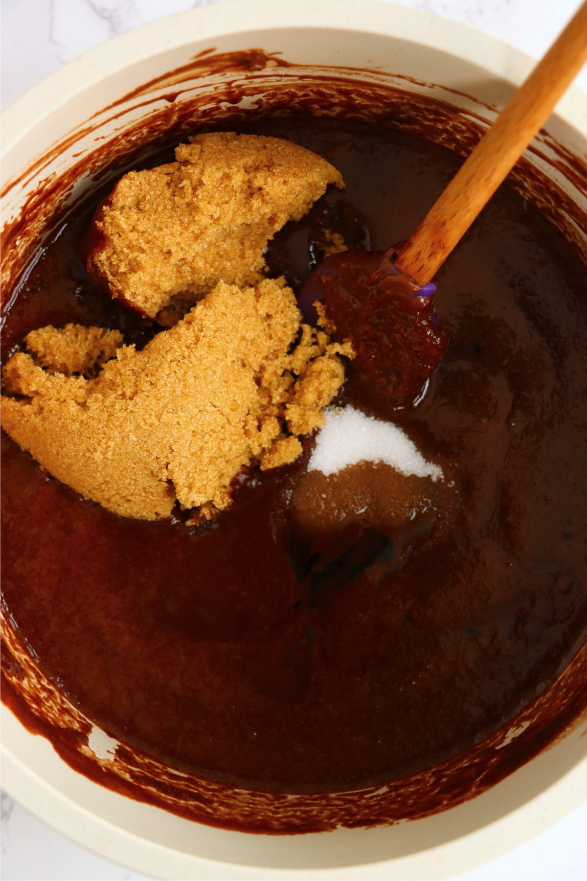 Melted chocolate being mixed together with brown sugar and granulated sugar.