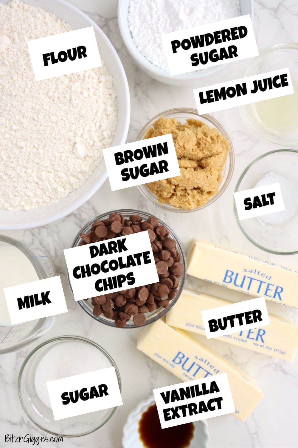 Dark chocolate chips, butter sticks, flour, brown sugar, powdered sugar, milk, and vanilla extract arranged in bowls and containers on a marble countertop.