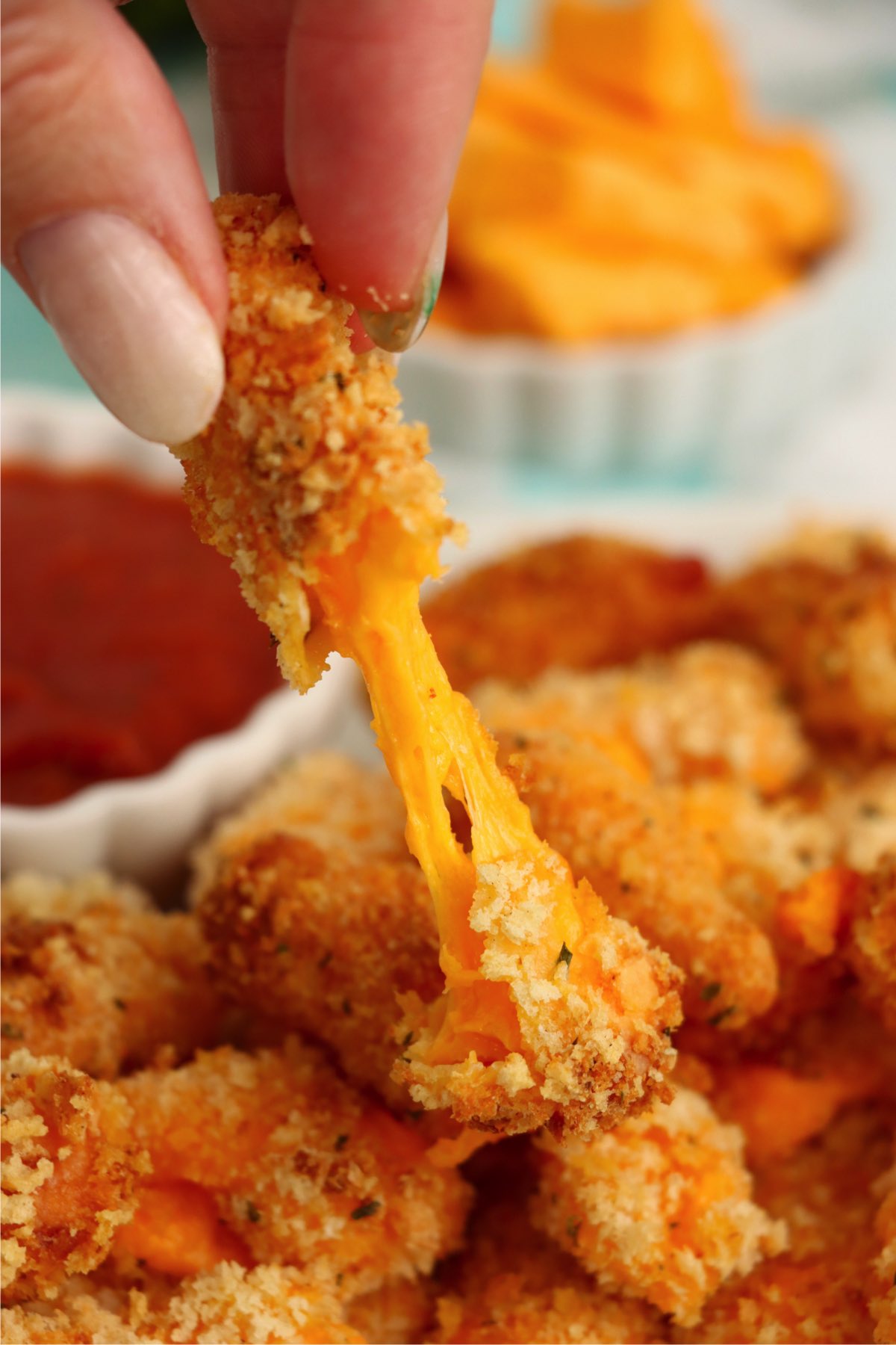 Air fryer cheese curd pulled apart showing melted cheese center.