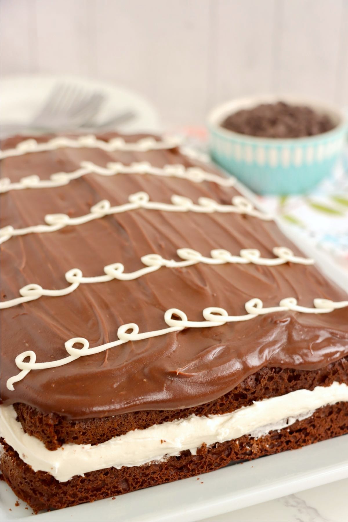 Decorated Hostess sheet cake with smooth chocolate frosting and piped white loops.
