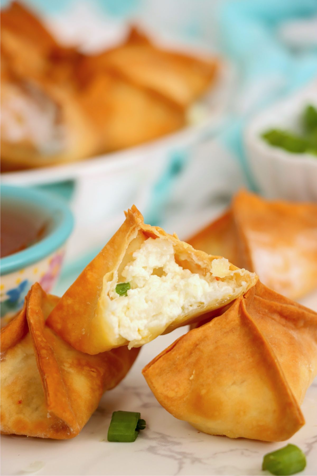Crab rangoon broken open showing creamy filling inside.