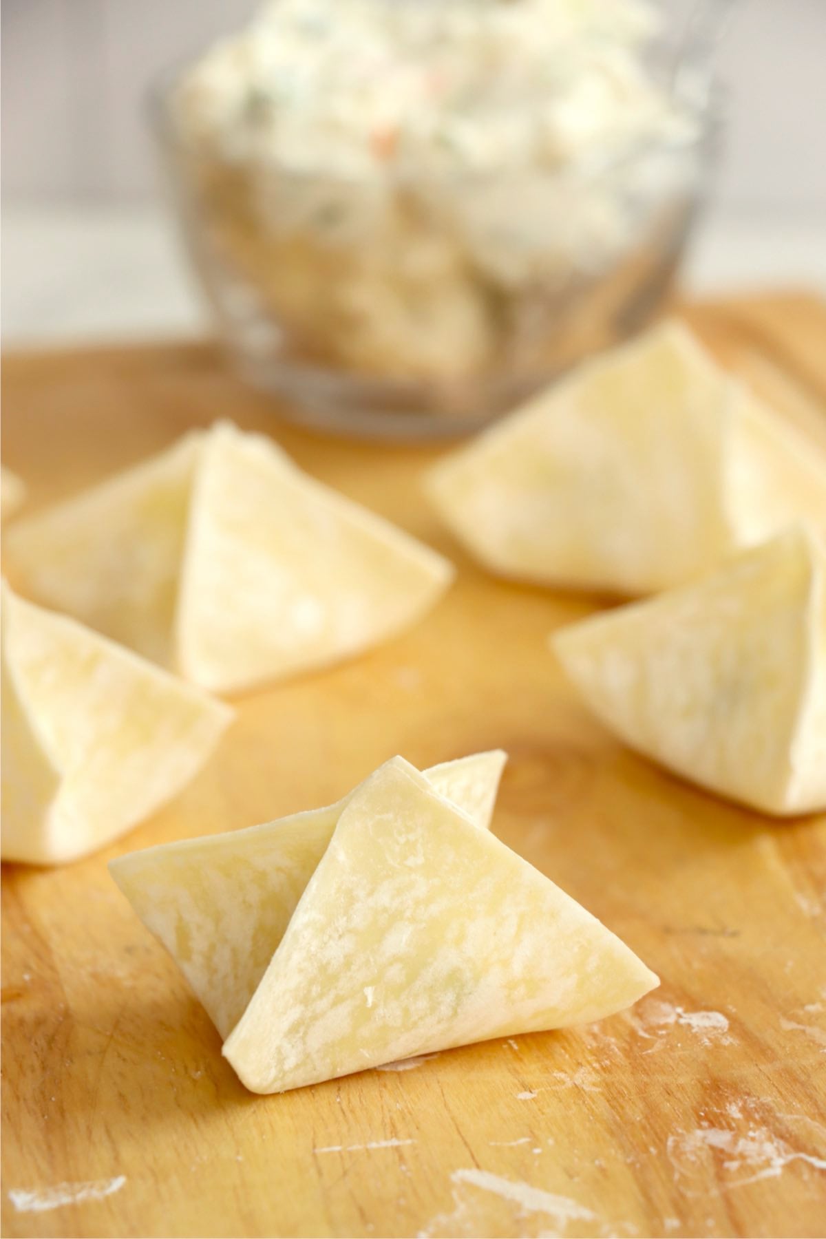 Uncooked crab rangoons folded and ready to cook.