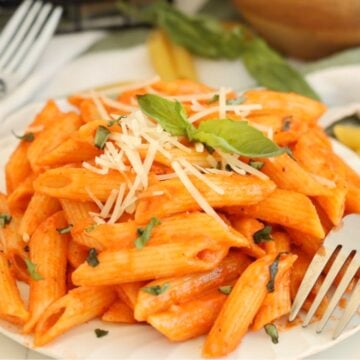 Creamy penne alla vodka garnished with basil and parmesan.