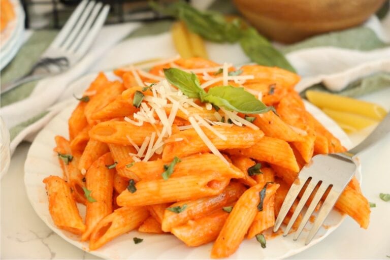 Creamy penne alla vodka garnished with basil and parmesan.