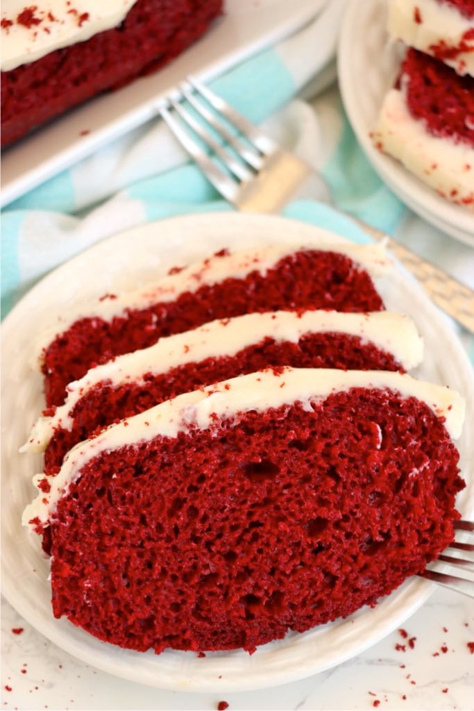 Sliced red velvet loaf cake with cream cheese frosting.