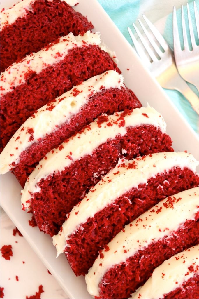 Thick slices of red velvet loaf cake layered with cream cheese frosting.