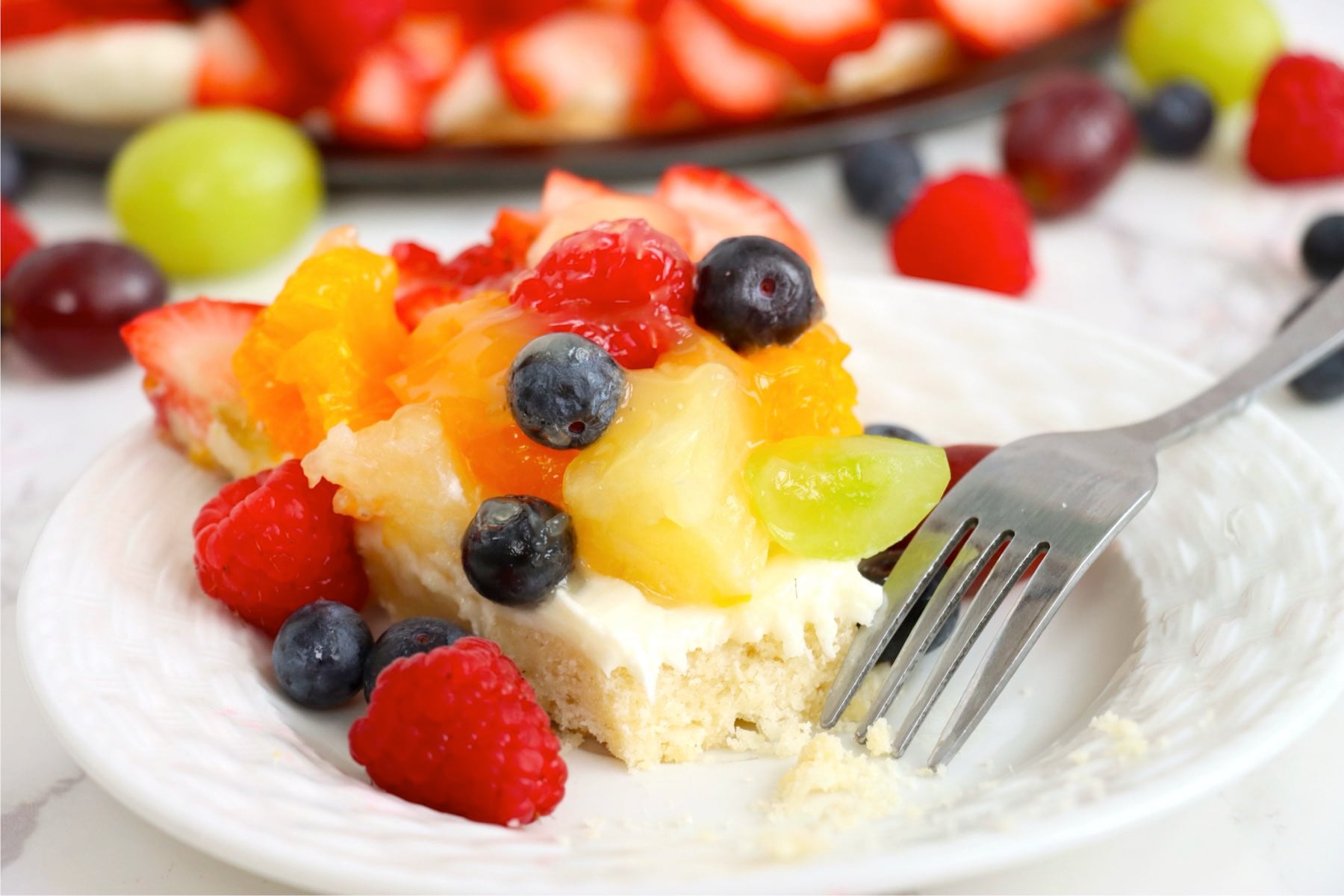 Fresh fruit tart with a bite taken out.