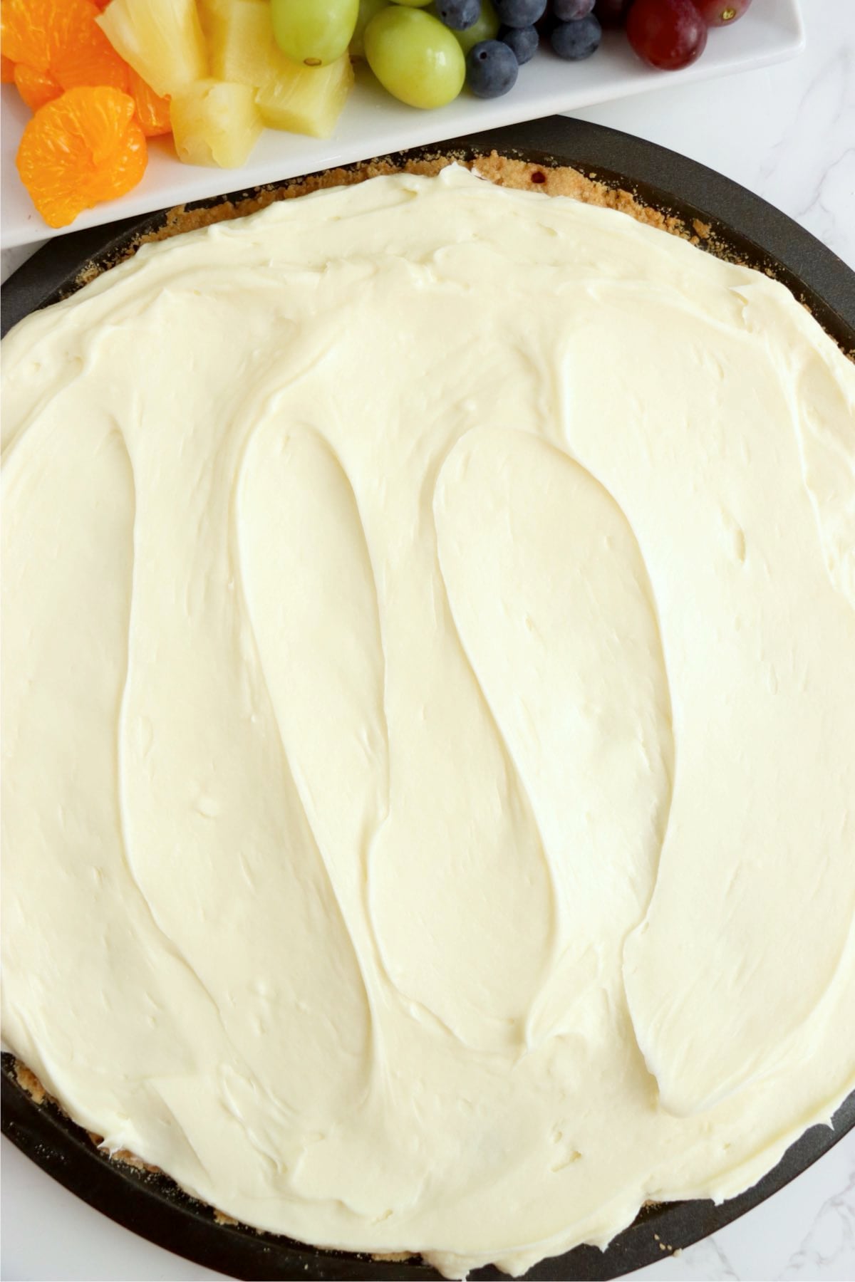 Smooth cream cheese filling spread evenly over the baked tart crust.