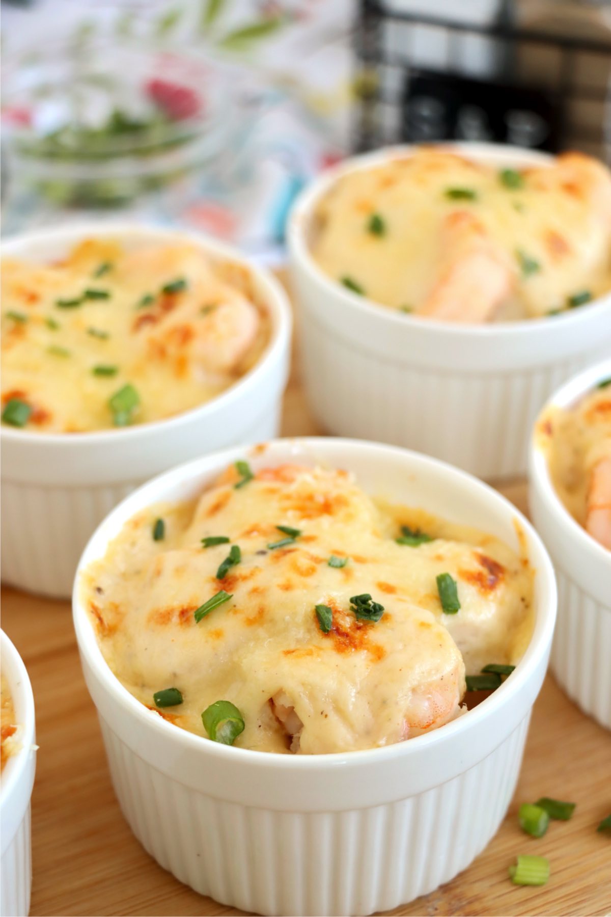 Baked Coquilles St. Jacques with golden creamy topping and green onions.