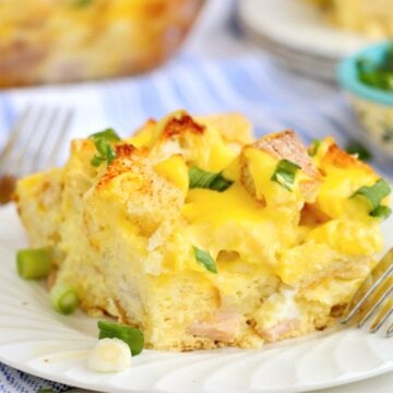 Single serving of eggs Benedict casserole on a white plate with green onions.