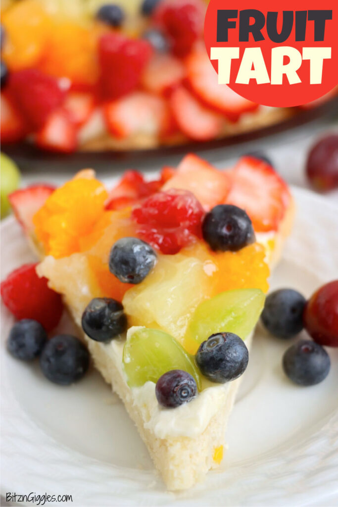 Detailed view of a fruit tart slice topped with pineapple, berries, and grapes.