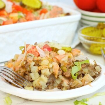 Serving of Big Mac casserole on a white plate with sauce and toppings.
