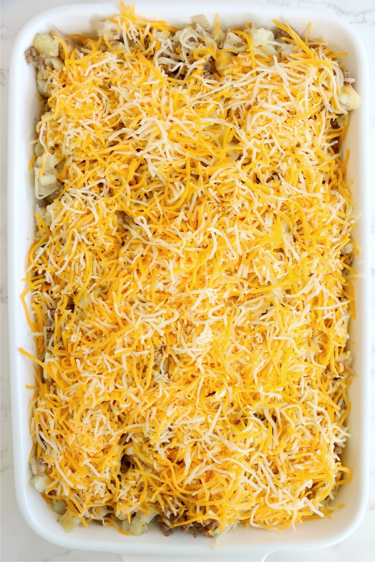 Shredded cheese layered over beef and hash brown mixture.