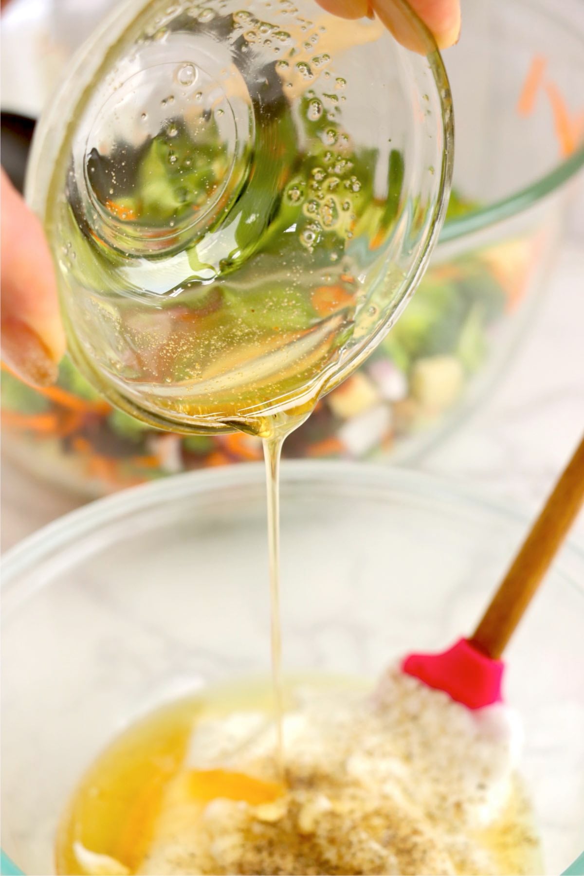 Honey being poured into a bowl to make a light, tangy yogurt dressing for broccoli salad.