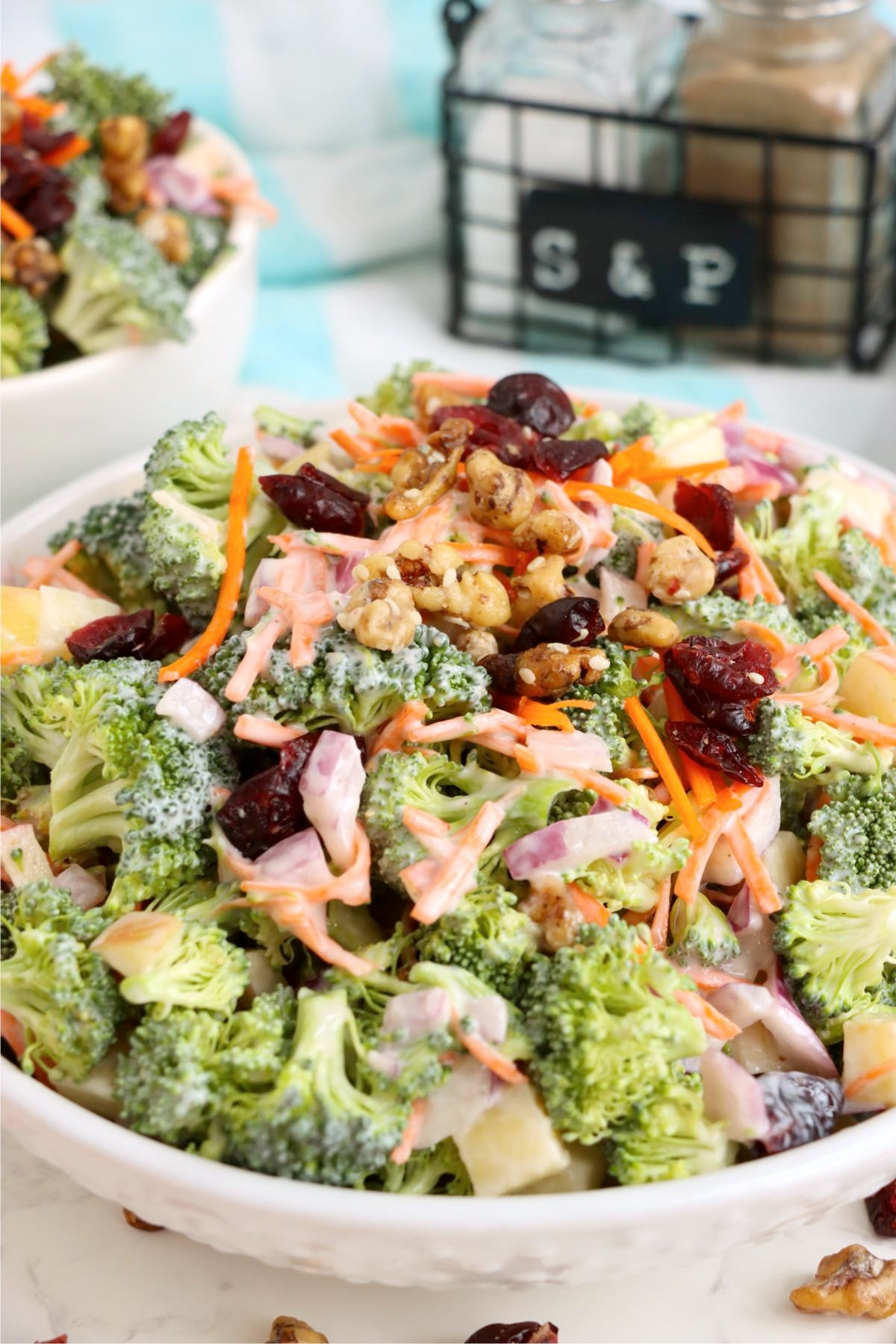 Fresh broccoli salad served in a white bowl with crunchy toppings and creamy dressing.