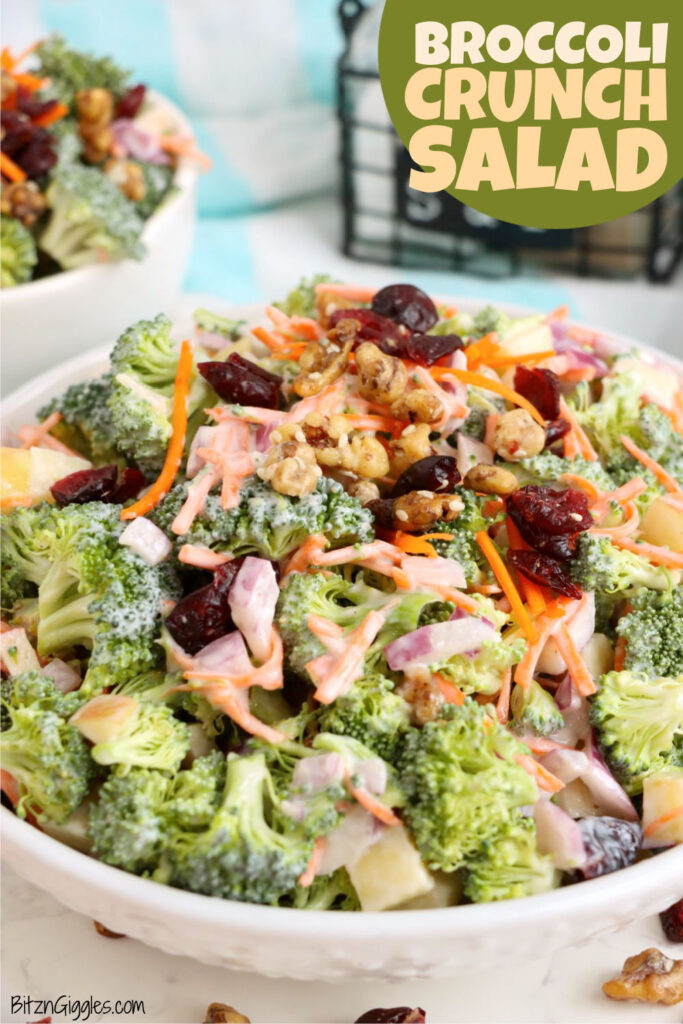 Bowl of broccoli crunch salad with creamy dressing, cranberries, walnuts, and fresh vegetables.