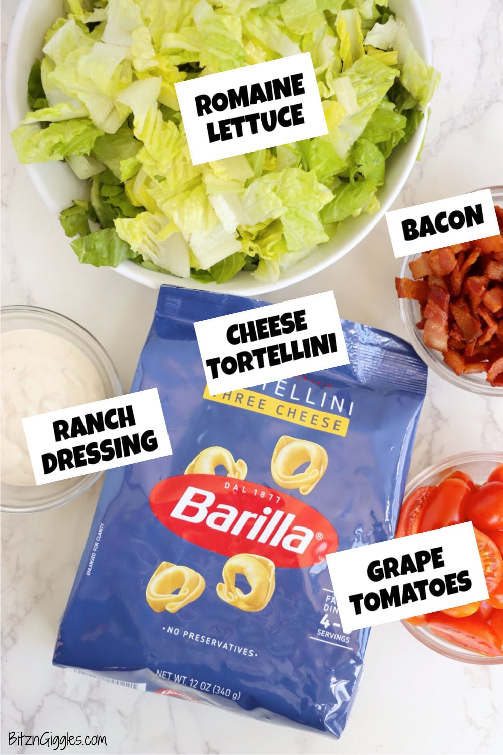 Ingredients for cold tortellini salad including romaine lettuce, cheese tortellini, ranch dressing, bacon, and grape tomatoes.