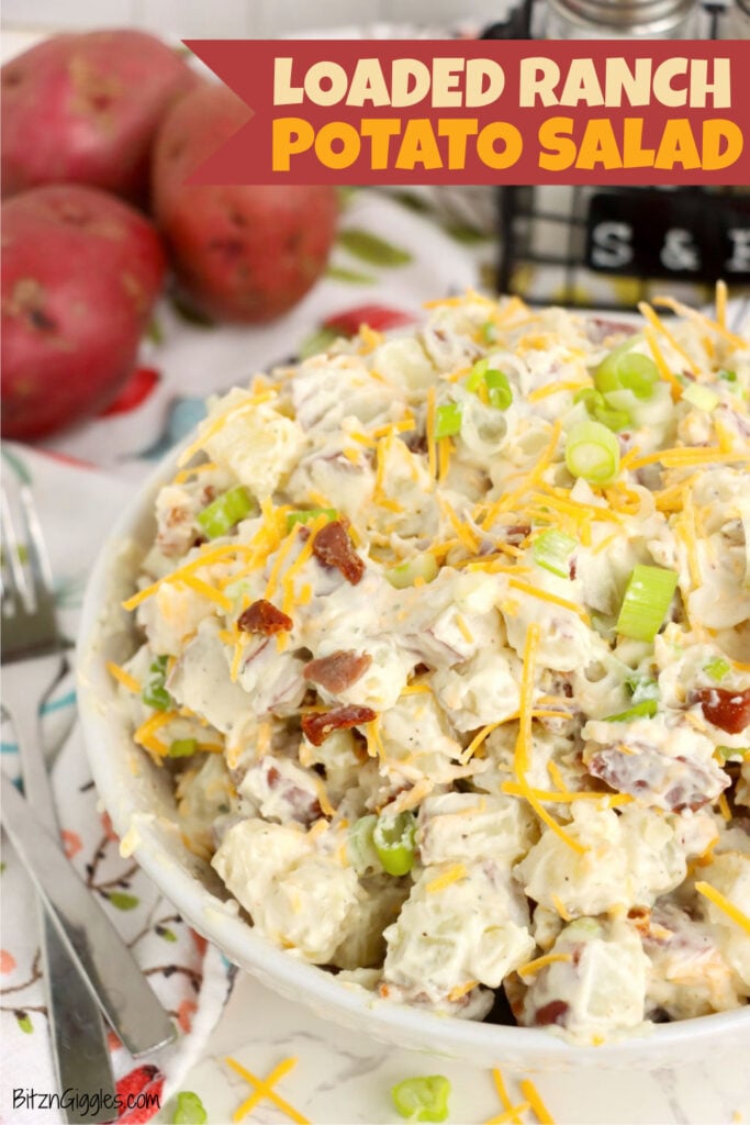 Large bowl of creamy potato salad with bacon, cheddar cheese and green onions ready to serve.
