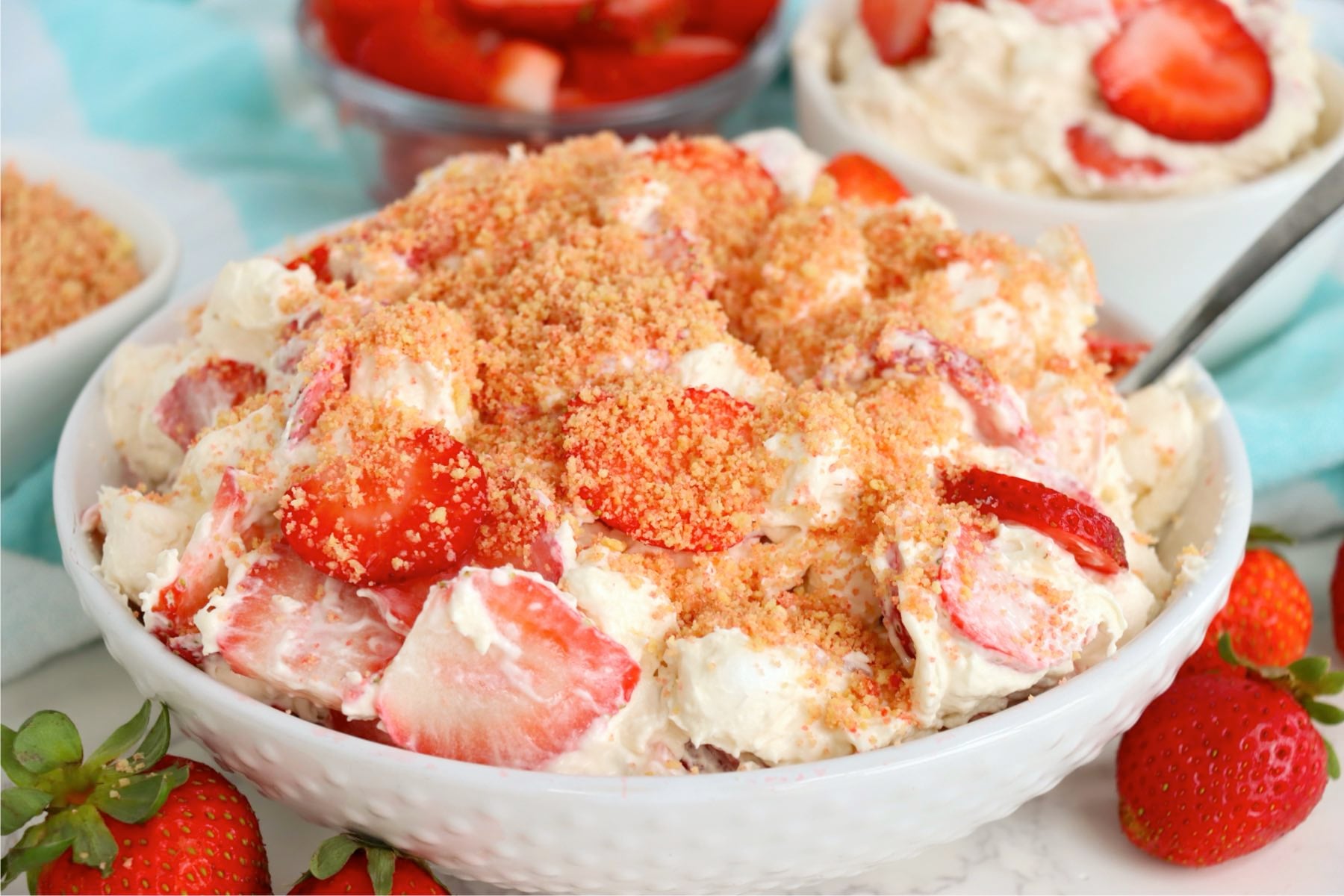 Strawberry Cheesecake Fluff recipe with creamy cheesecake filling, strawberries, marshmallows, and crunchy topping.