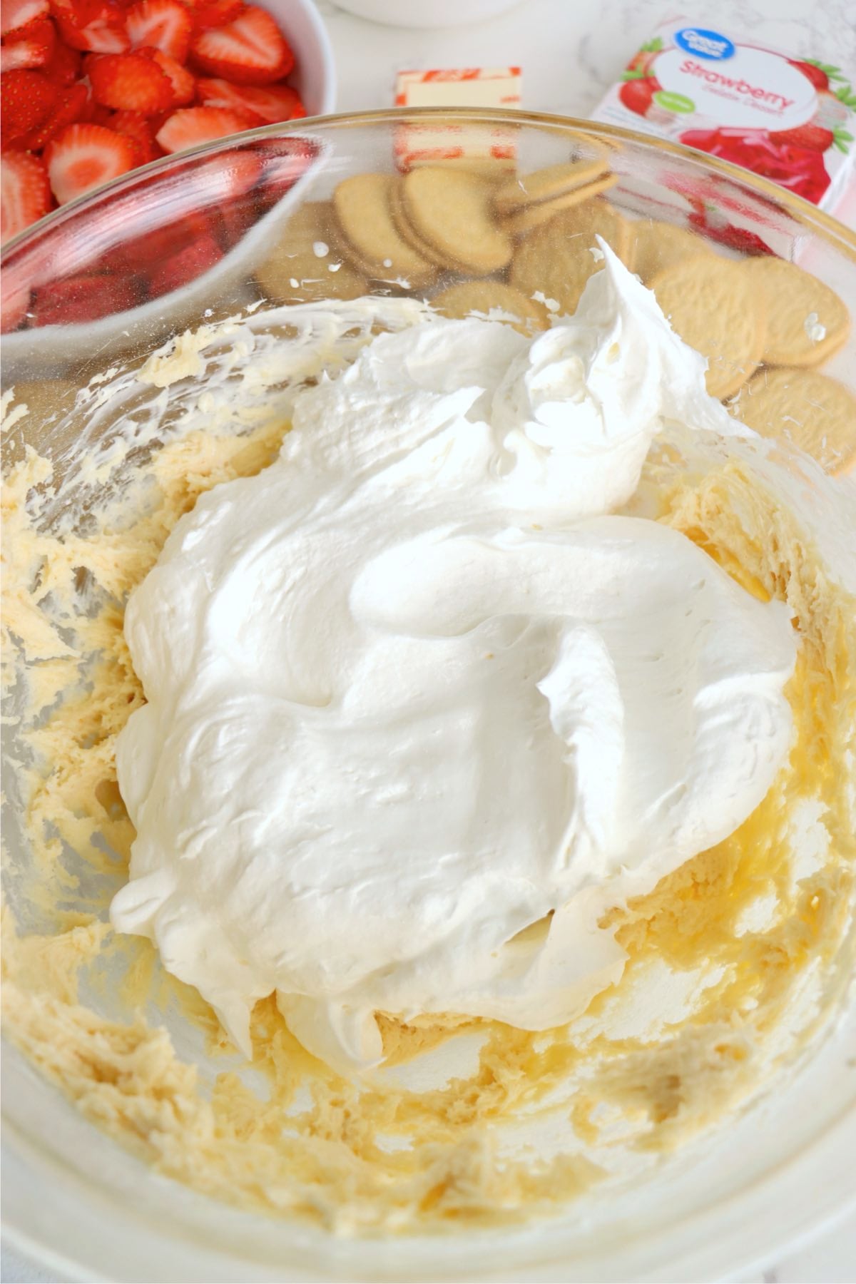 Whipped topping folded into cheesecake mixture for a fluffy texture.