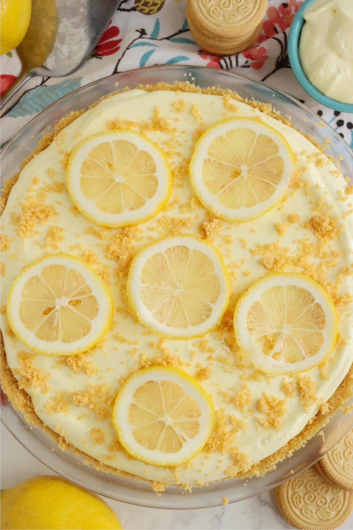Chilled pale yellow pie topped with thin lemon rounds and golden cookie crumbs.