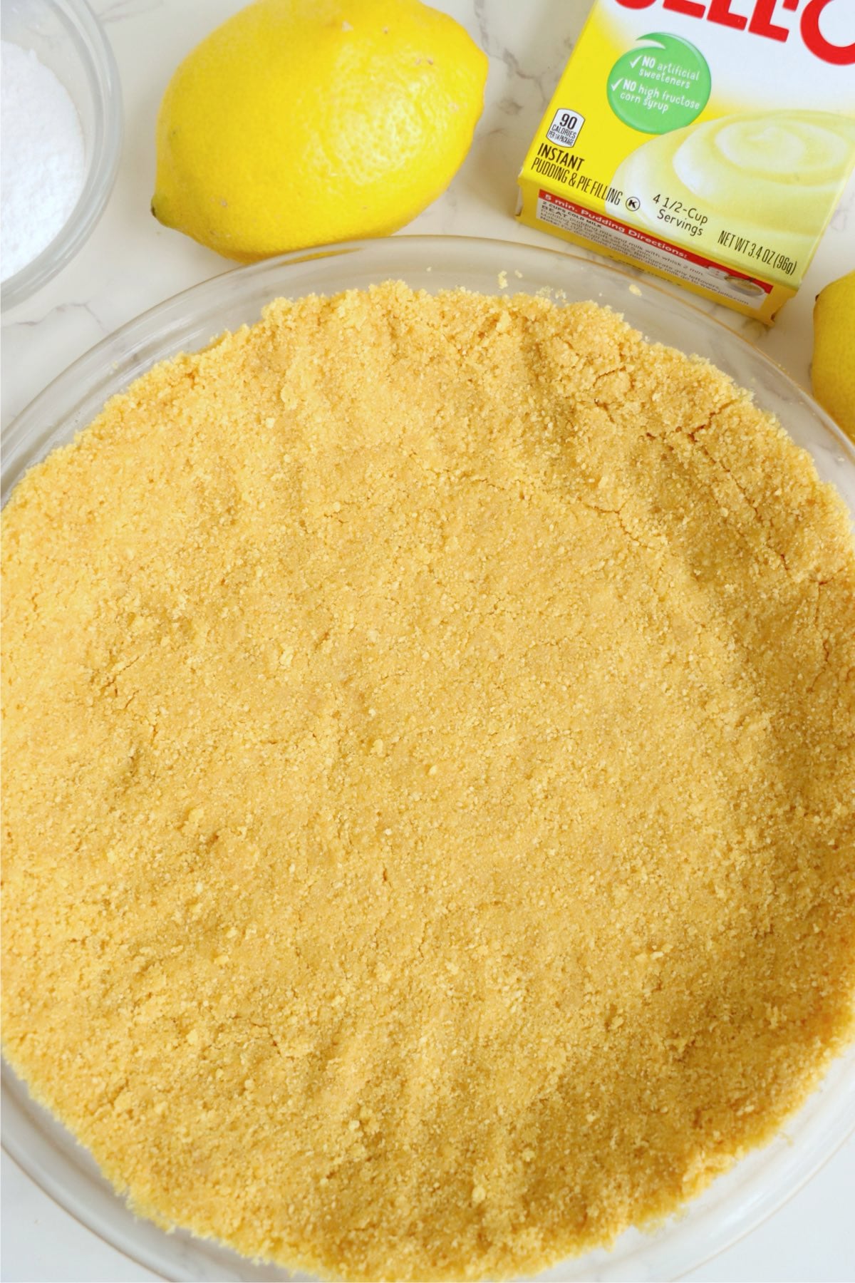Even layer of fine golden crumbs pressed across glass pie plate and up sides.